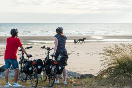 image de femme à vélo devant une plage